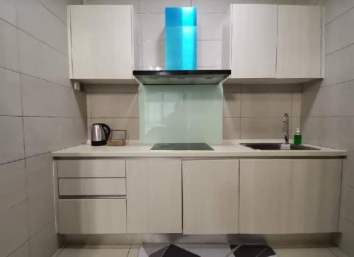 a kitchen with white cabinets and a sink at Conezion Residence Putrajaya WiFi Netflix in Putrajaya