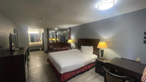 a hotel room with a bed and a desk at Days Inn & Suites by Wyndham Winnie in Winnie