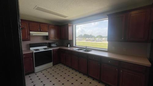 a kitchen with a large window and a sink at Days Inn & Suites by Wyndham Winnie in Winnie