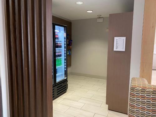 a waiting room with a television and a drink cooler at Holiday Inn Express - Eunice by IHG in Eunice