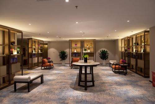 a lobby with a table and chairs in a building at Zhuo Ruiyunrui Hotel in Dongliucun