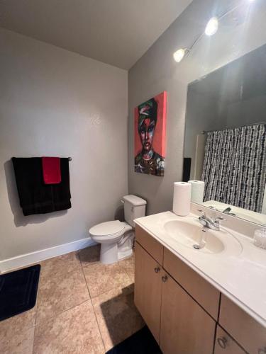 a bathroom with a sink and a toilet and a mirror at Stunning 2 bedroom Downtown Ft Worth in Fort Worth