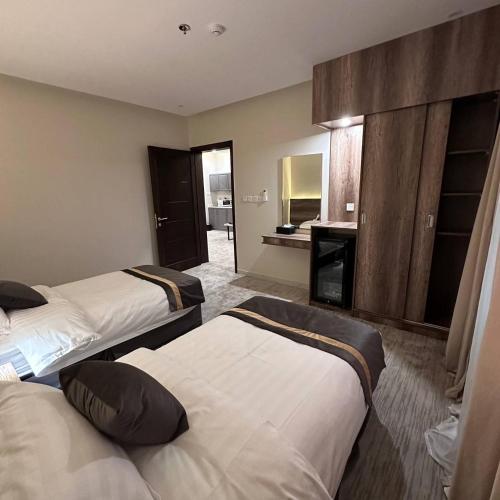 a hotel room with two beds and a bathroom at بارك المدينة للشقق المخدومة in Al Madinah