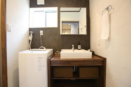 une salle de bain avec un lavabo blanc et un miroir dans l'établissement BETSUINN MINI, à Hakuba