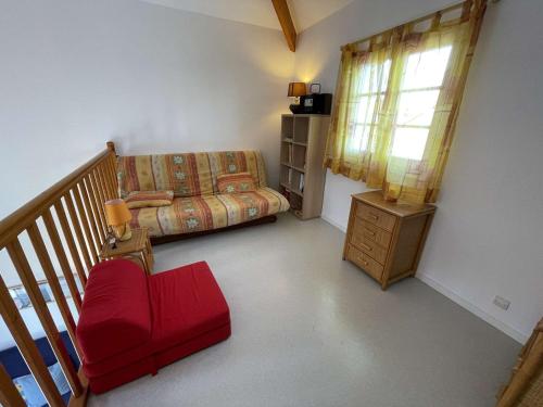 - un salon avec un canapé et un fauteuil rouge dans l'établissement Maison de Vacances 8 Pers à 300m Plage avec Terrasse et Parking, Saint-Jean-de-Monts - FR-1-224C-272, à Saint-Jean-de-Monts