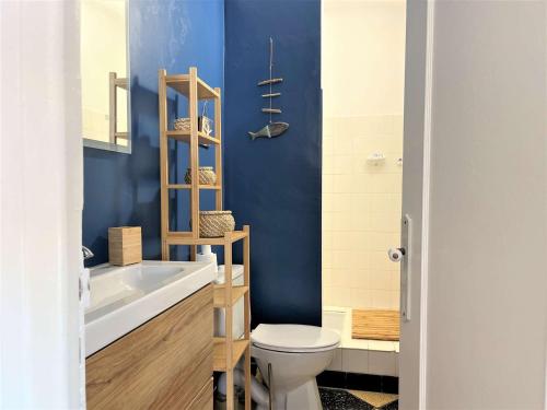 une salle de bain avec toilettes et un mur bleu dans l'établissement Appartement 2 pièces avec terrasse et vue mer à 50m de la plage - FR-1-229C-84, à Port-la-Nouvelle