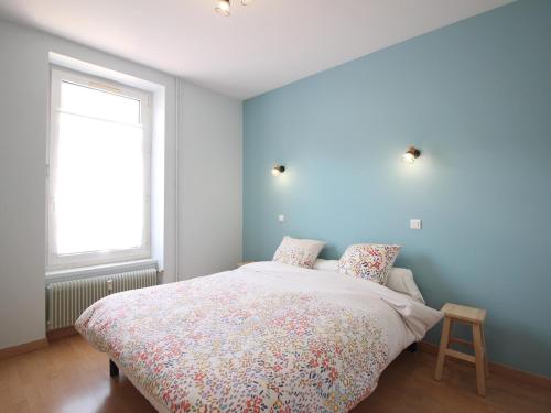 a bedroom with a bed with a blue wall at Bel appartement 3*** La Bourboule, 6 pers, Wifi inclus - FR-1-608-250 in La Bourboule