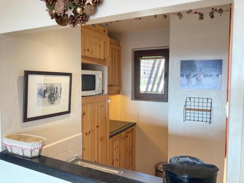 a kitchen with wooden cabinets and a microwave at Appartement Avoriaz, 3 pièces, 7 personnes - FR-1-634-89 in Morzine