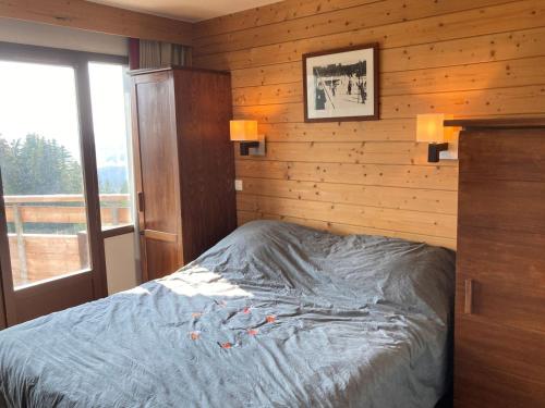 a bedroom with a bed with a wooden wall at Appartement Avoriaz, 3 pièces, 7 personnes - FR-1-634-89 in Morzine