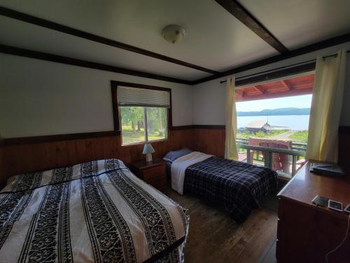 1 Schlafzimmer mit 2 Betten und einem Fenster mit Aussicht in der Unterkunft Chalet with great lake view in Gracefield