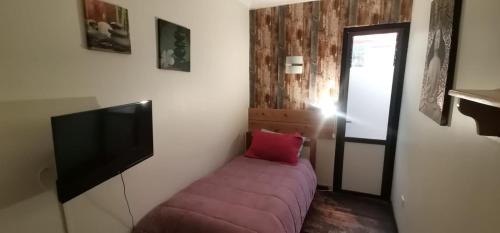 a room with a couch and a flat screen tv at Hostal La Casa del Puente in Santiago