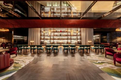 a restaurant with a bar with tables and chairs at Pan Pacific Singapore in Singapore
