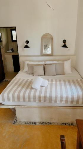a large white bed in a room with at La Conchita Tulum in Tulum