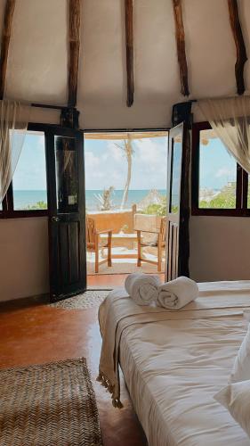 a bedroom with two beds and a view of the ocean at La Conchita Tulum in Tulum
