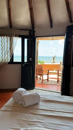 a bedroom with a bed with a view of the ocean at La Conchita Tulum in Tulum