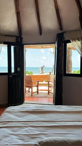 a bedroom with a bed and a view of the ocean at La Conchita Tulum in Tulum