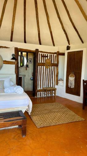 a bedroom with a bed and a table in a room at La Conchita Tulum in Tulum