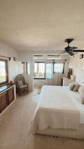 a bedroom with a large bed with a ceiling fan at La Conchita Tulum in Tulum