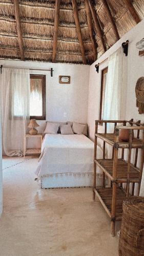 a bedroom with a bed and a chair in it at La Conchita Tulum in Tulum