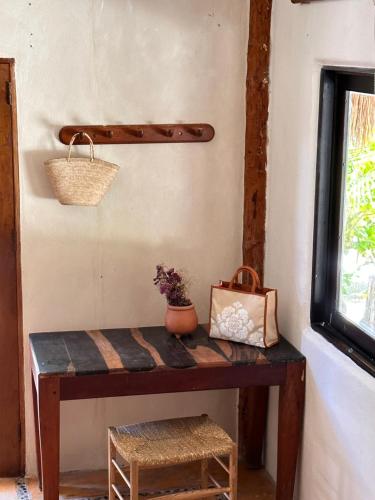 a room with a wooden table with a plant on it at La Conchita Tulum in Tulum
