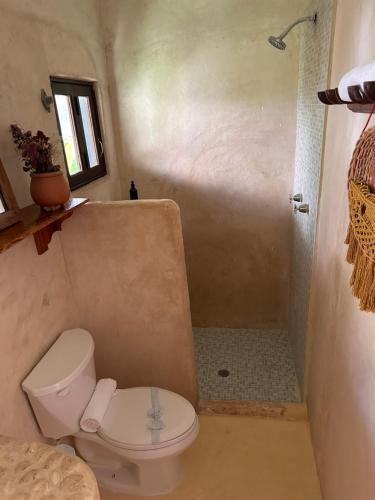 a bathroom with a toilet and a shower at La Conchita Tulum in Tulum