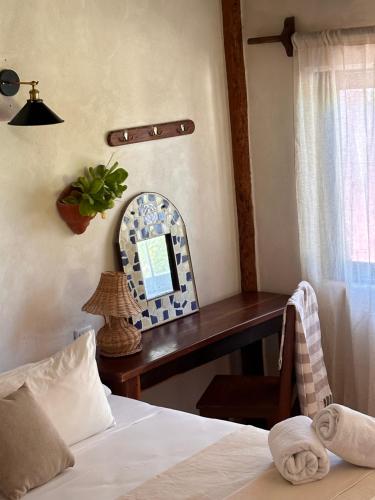a bedroom with a bed and a table with a mirror at La Conchita Tulum in Tulum