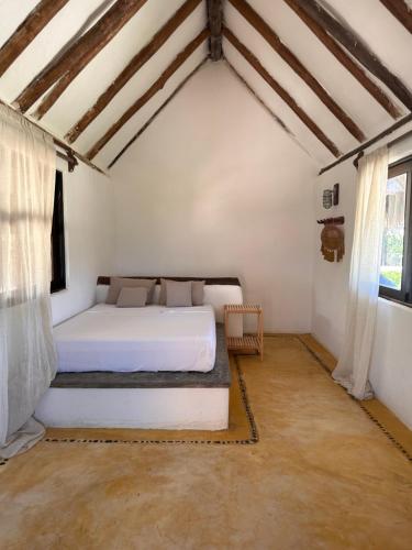 a bedroom with a white bed in a room at La Conchita Tulum in Tulum