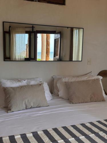 a large white bed with a large mirror above it at La Conchita Tulum in Tulum