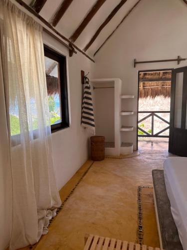 a bedroom with a bed and a window at La Conchita Tulum in Tulum