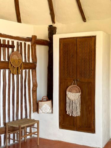 a room with a wooden door and a chair at La Conchita Tulum in Tulum