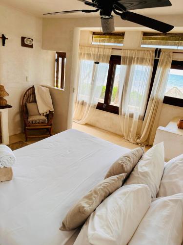 a large white bed in a room with a window at La Conchita Tulum in Tulum