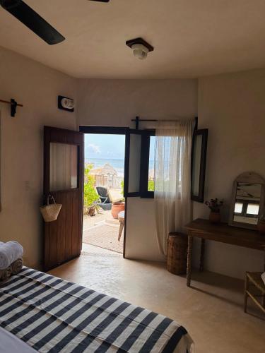 a bedroom with a bed and a sliding glass door at La Conchita Tulum in Tulum