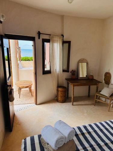 a room with a bed and a mirror and a door at La Conchita Tulum in Tulum