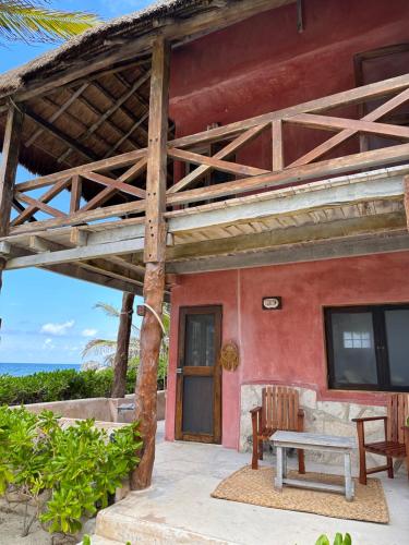 a porch of a house with a table and a bench at La Conchita Tulum in Tulum