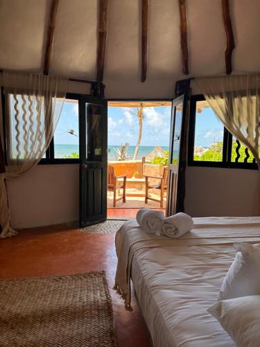 a bedroom with two beds and a view of the ocean at La Conchita Tulum in Tulum