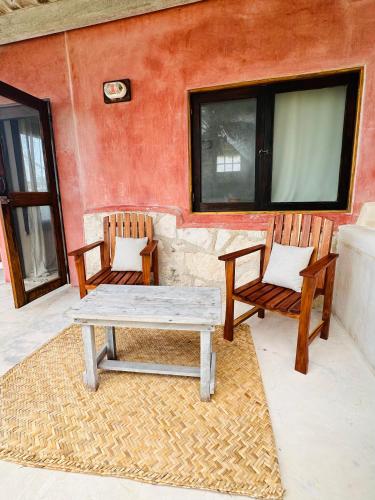 two chairs and a picnic table on a patio at La Conchita Tulum in Tulum