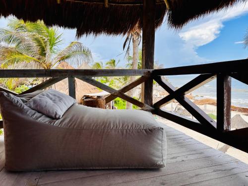 a bed on a porch with a view of the ocean at La Conchita Tulum in Tulum