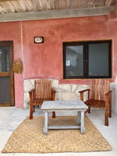 a picnic table and two benches in front of a house at La Conchita Tulum in Tulum