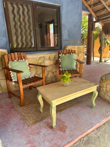 two chairs and a wooden table and a bench at La Conchita Tulum in Tulum