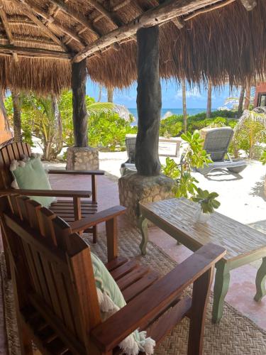 a patio with benches and a table and chairs at La Conchita Tulum in Tulum