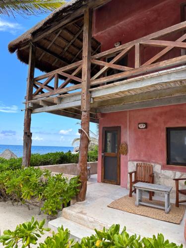 a house on the beach with a bench and a porch at La Conchita Tulum in Tulum