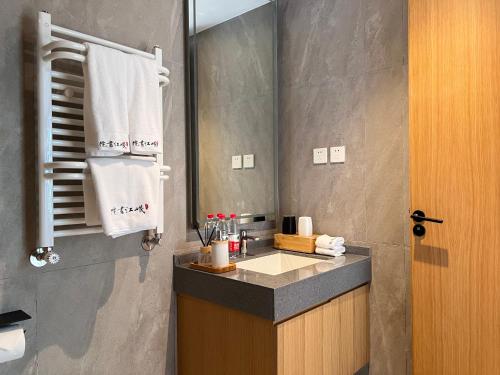 a bathroom with a sink and a mirror at 岷江书院人文度假酒店 in Chengdu