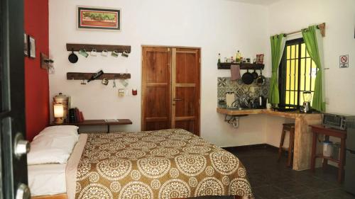 1 dormitorio con 1 cama y puerta de madera en Habitacion Roja / Casa del Café en Campeche