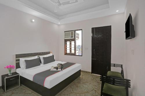 een slaapkamer met een groot bed en een stoel bij The Royal Fern in Farrukhnagar