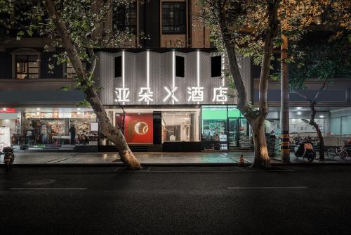 a store front at night with trees in front of it at Atour X Hotel - Taikoo Li Chengdu in Chengdu