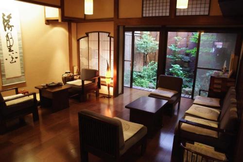 a living room with chairs and tables in a room at Ryokan Tanabe in Takayama