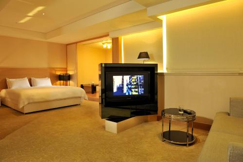 台南的住宿－亞帝大飯店 ，配有一张床和一台平面电视的酒店客房