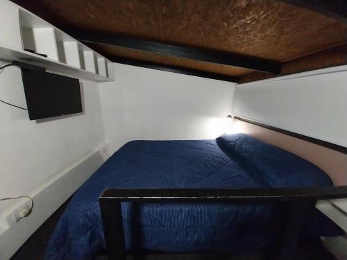 Un pequeño dormitorio con una cama azul. en Espacio km3 en Comodoro Rivadavia