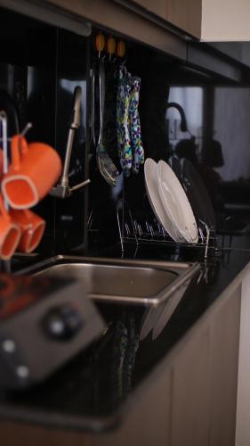 un bancone della cucina con lavello, piatti e utensili di El Hogar a Kiambu