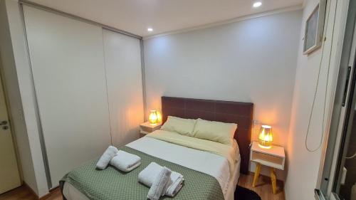 a small bedroom with a bed and two night stands at Exclusivo Dpto, Zona Residencial in Godoy Cruz